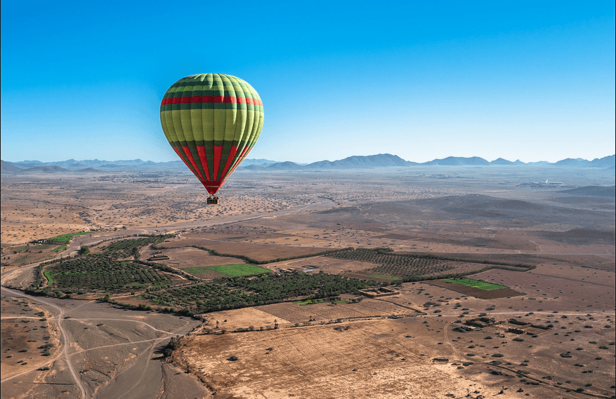 Hot air balloon gliding over peaceful rural landscapes near Marrakech